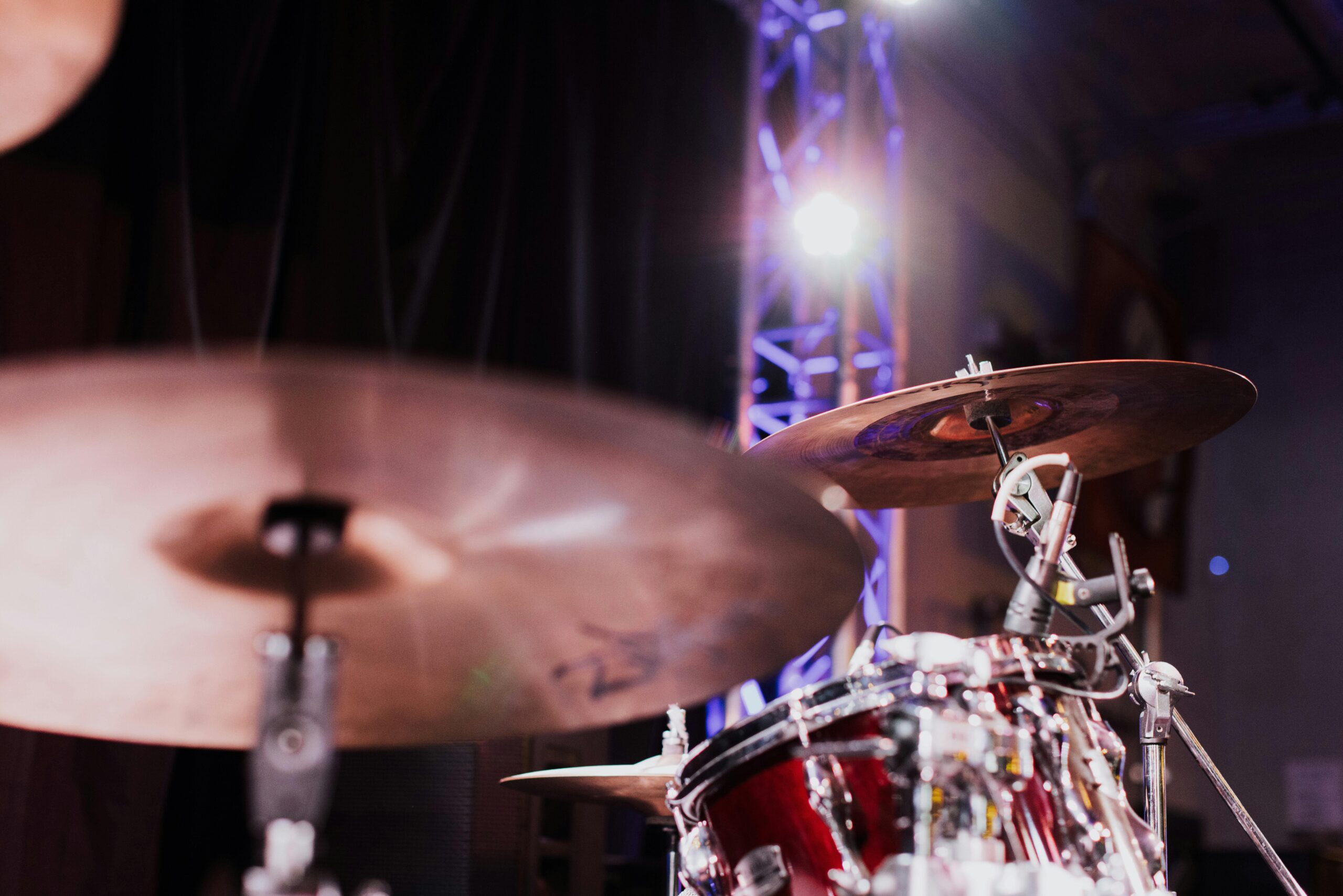 Dynamic close-up of a drum set on a stage with vibrant lighting, capturing the essence of live music performance.